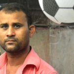 Worker standing in front of an inflatable football ball