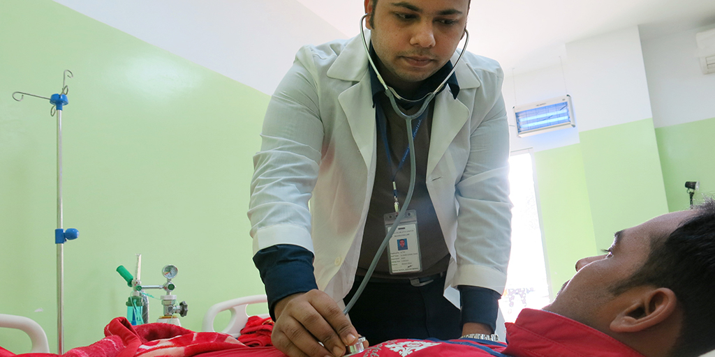 Dr Khaled Tamim visits a patient in the male medical room of Crown Wears factory Newly employed doctor Khaled Tamim visits a patient in the male medical room of Crown Wears factory. © Elisa Oddone/Better Work Bangladesh